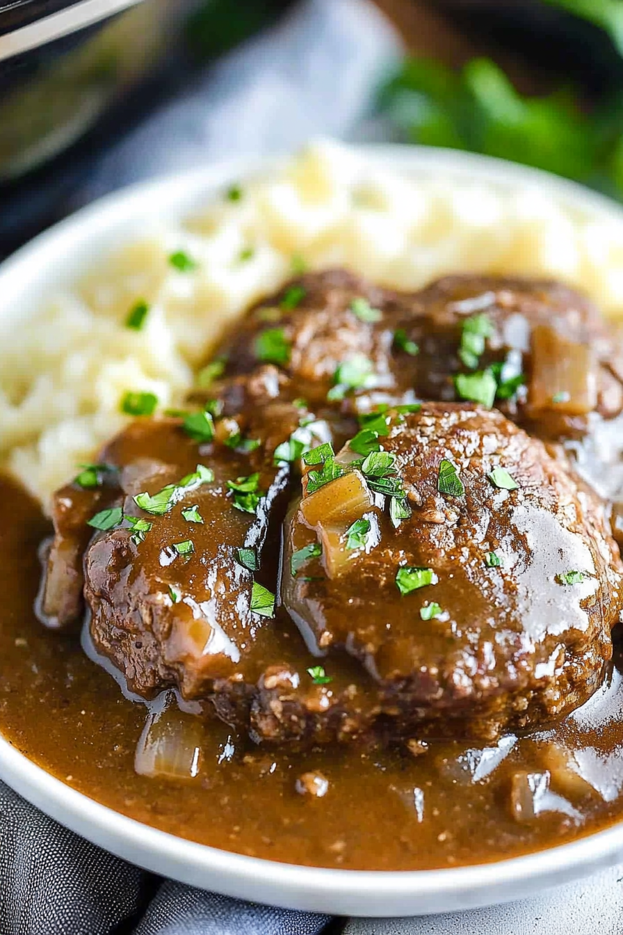 Beef patties browning in a skillet